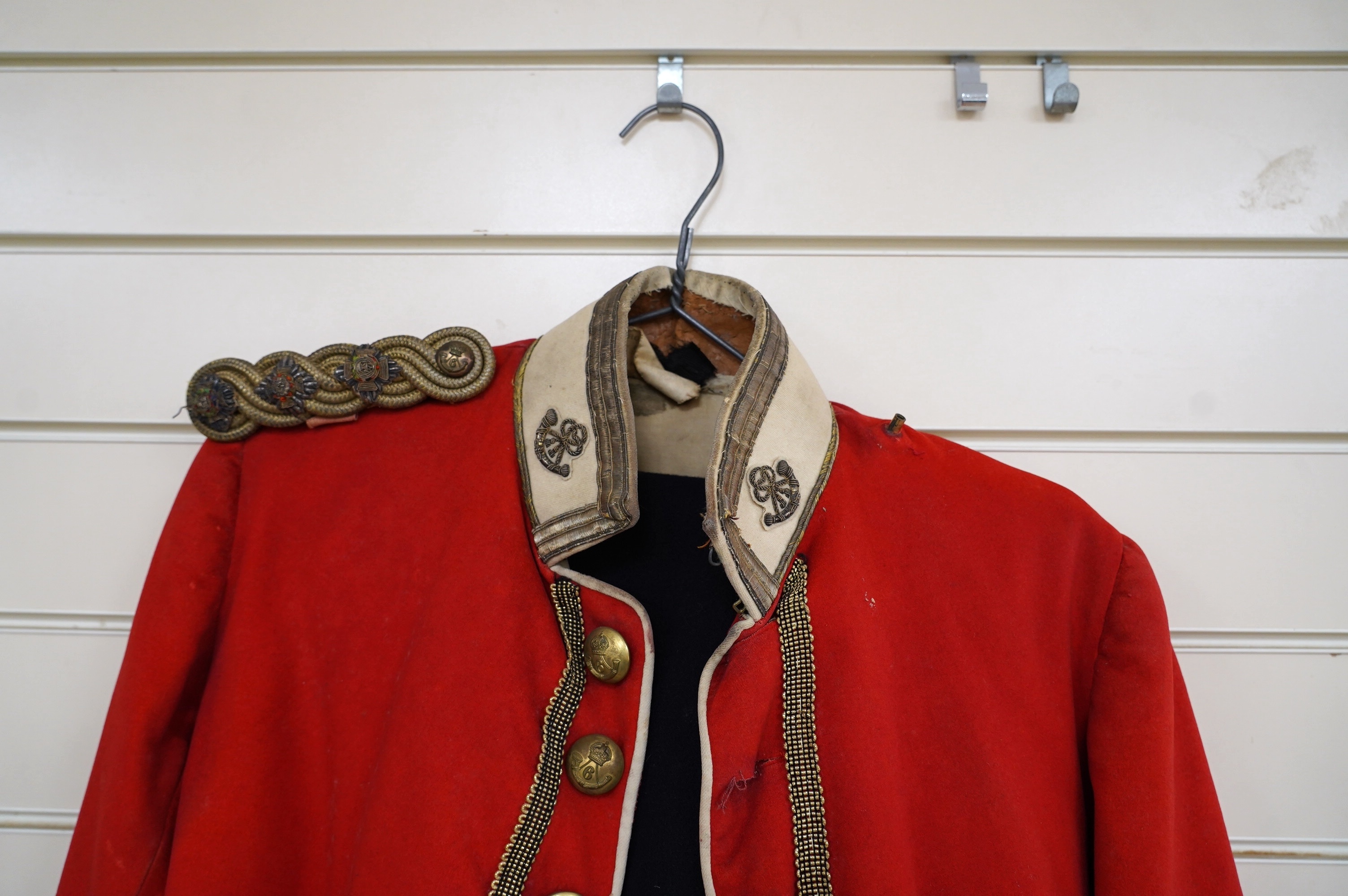 A Sixth Light Infantry officer’s uniform with epaulettes, comprising jacket and dress trousers. Condition - poor to fair, some staining and moth damage, etc.